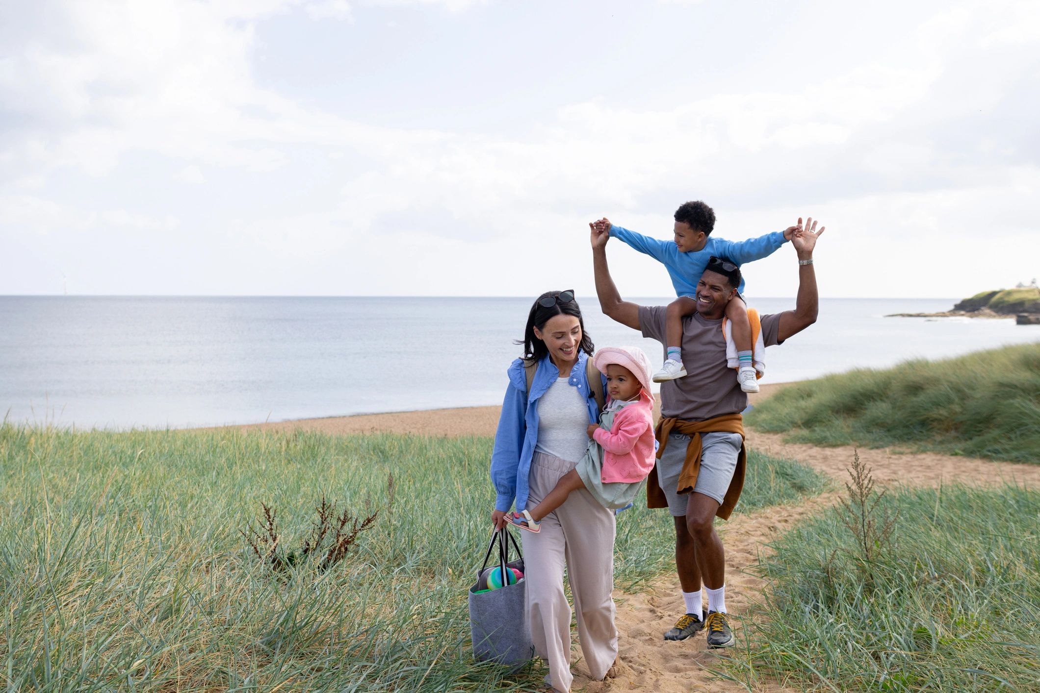 Family walking toward the beach with children