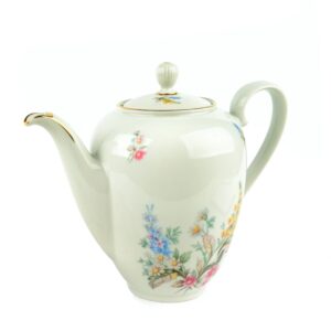 Vintage porcelain teapot with floral pattern on white background.